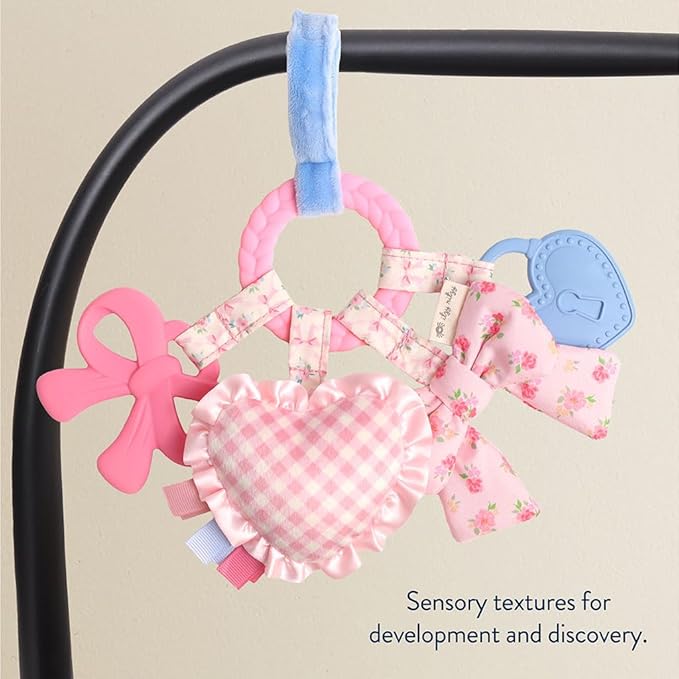 Itzy Ritzy Teething Activity Toy - Bitzy Busy Ring Infant Teething Toy Features Braided Teether & Dangling Toys, Includes Textured Ribbons, Crinkle Sound & Jingle Bell - 0 Months & Up (Pink Bow)