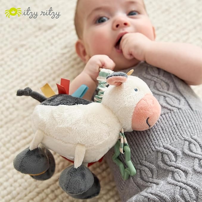 Itzy Ritzy Link & Love Toy for Stroller or Car Seat – Features Textured Ribbons, Crinkle Sounds, Clinking Rings & Silicone Teether – Designed for Ages 0 Months and Up (Cow)